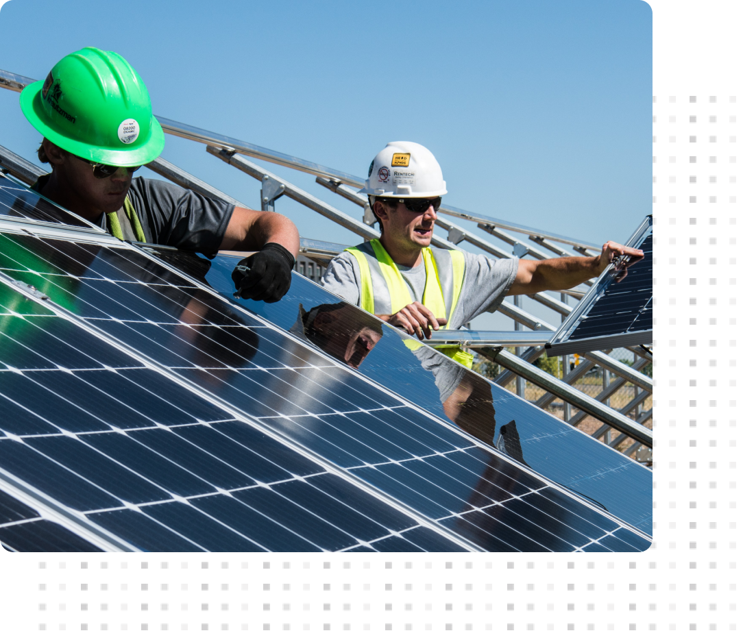 two employees installing ground mount solar panels